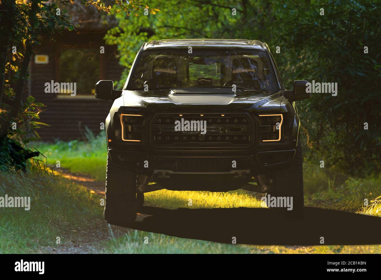 Ford Raptor che guida la strada forestale che conduce al foresters lodge Foto Stock