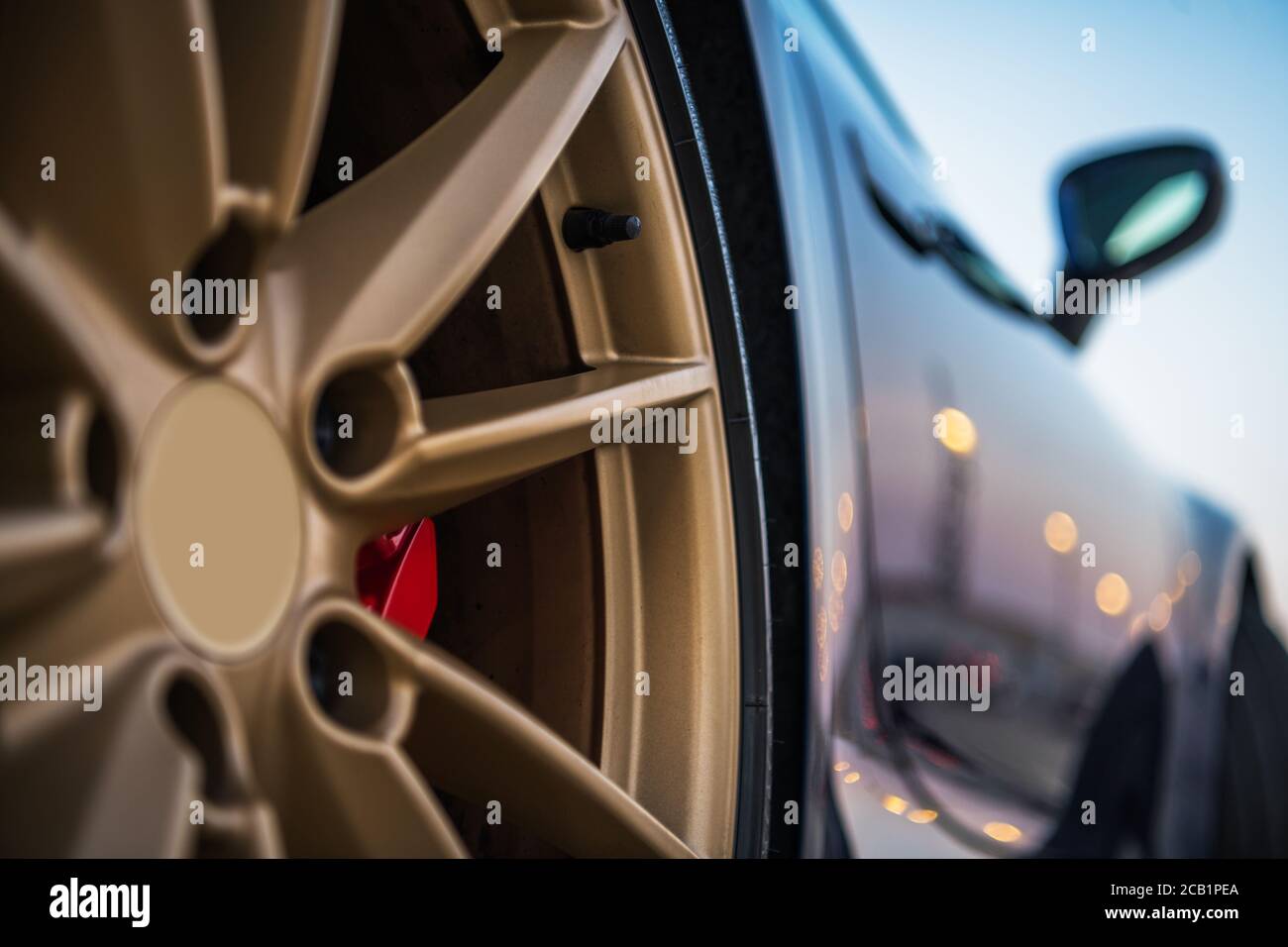 Vista posteriore laterale di un'automobile sportiva e pneumatico di lusso esotico con bordo di colore dorato. Foto Stock