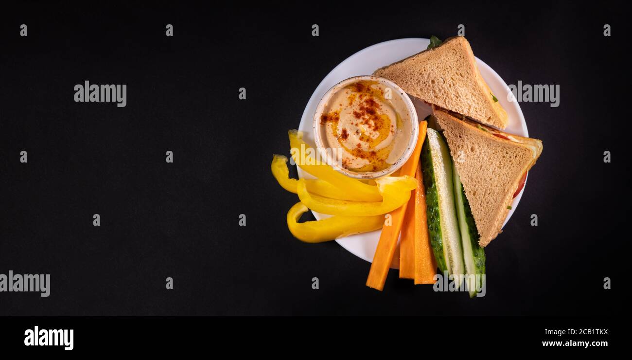 Bagno di hummus, verdure e pane su un piatto, vista dall'alto con spazio per la copia. Pasto vegano sano o pranzo, a base di piante e cibo ricco di vitamine Foto Stock