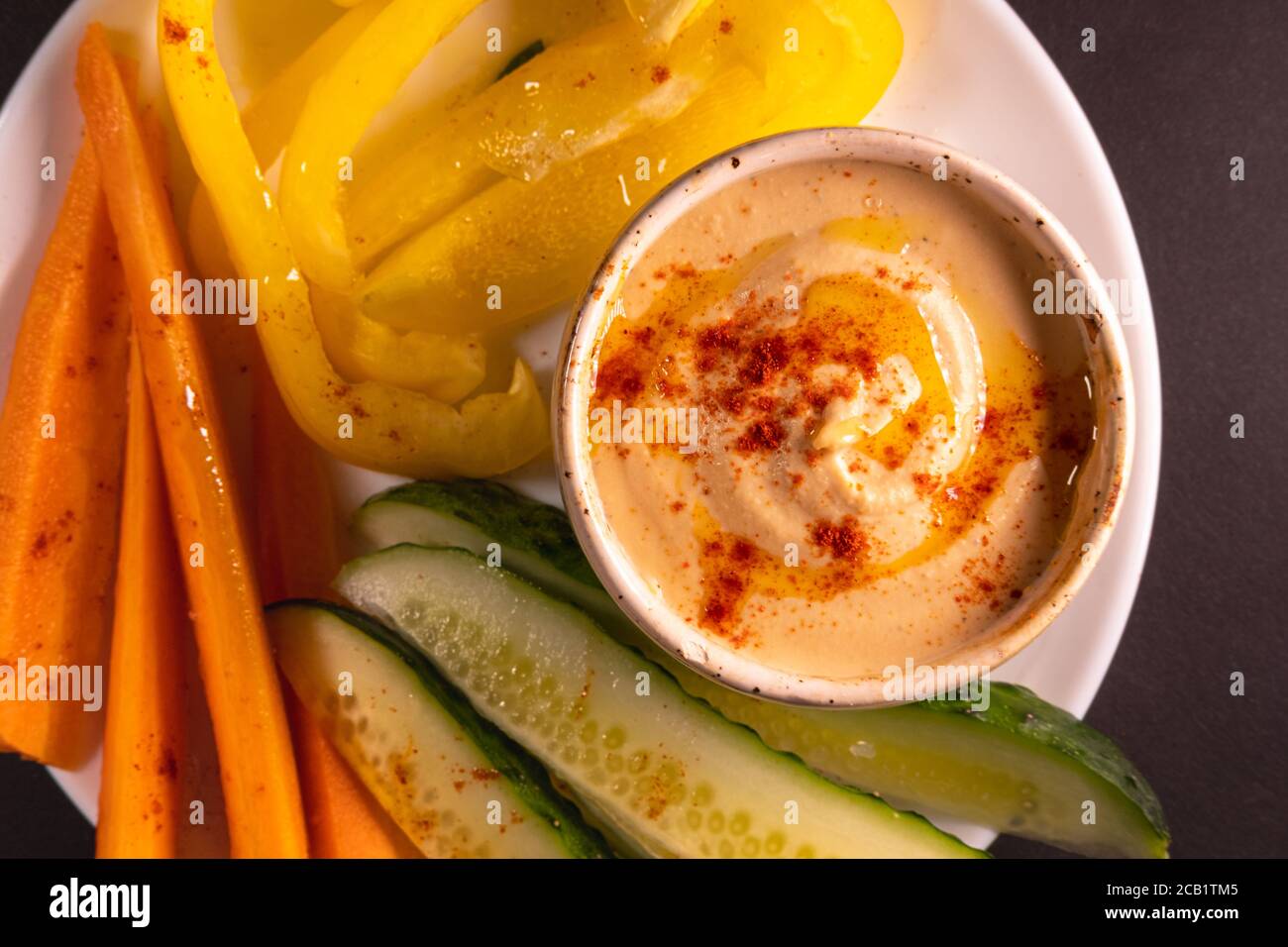 Bagno di hummus e verdure su un piatto, vista dall'alto con spazio per la copia. Pasto vegano sano o antipasto, a base di piante e cibo ricco di vitamine Foto Stock