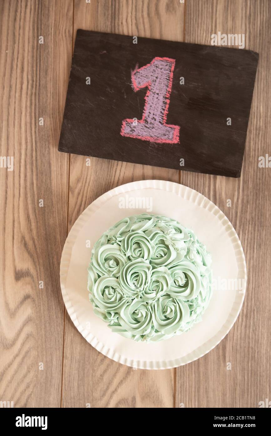 Vista dall'alto verticale di una torta di rose verde con il numero 1 scritto su una lavagna nera Foto Stock
