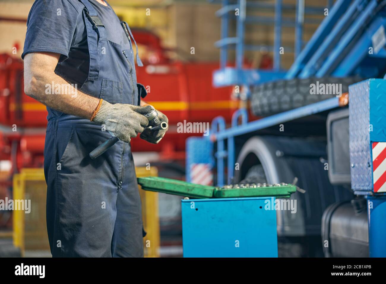 Riparatore professionista che sceglie lo strumento necessario per il lavoro Foto Stock