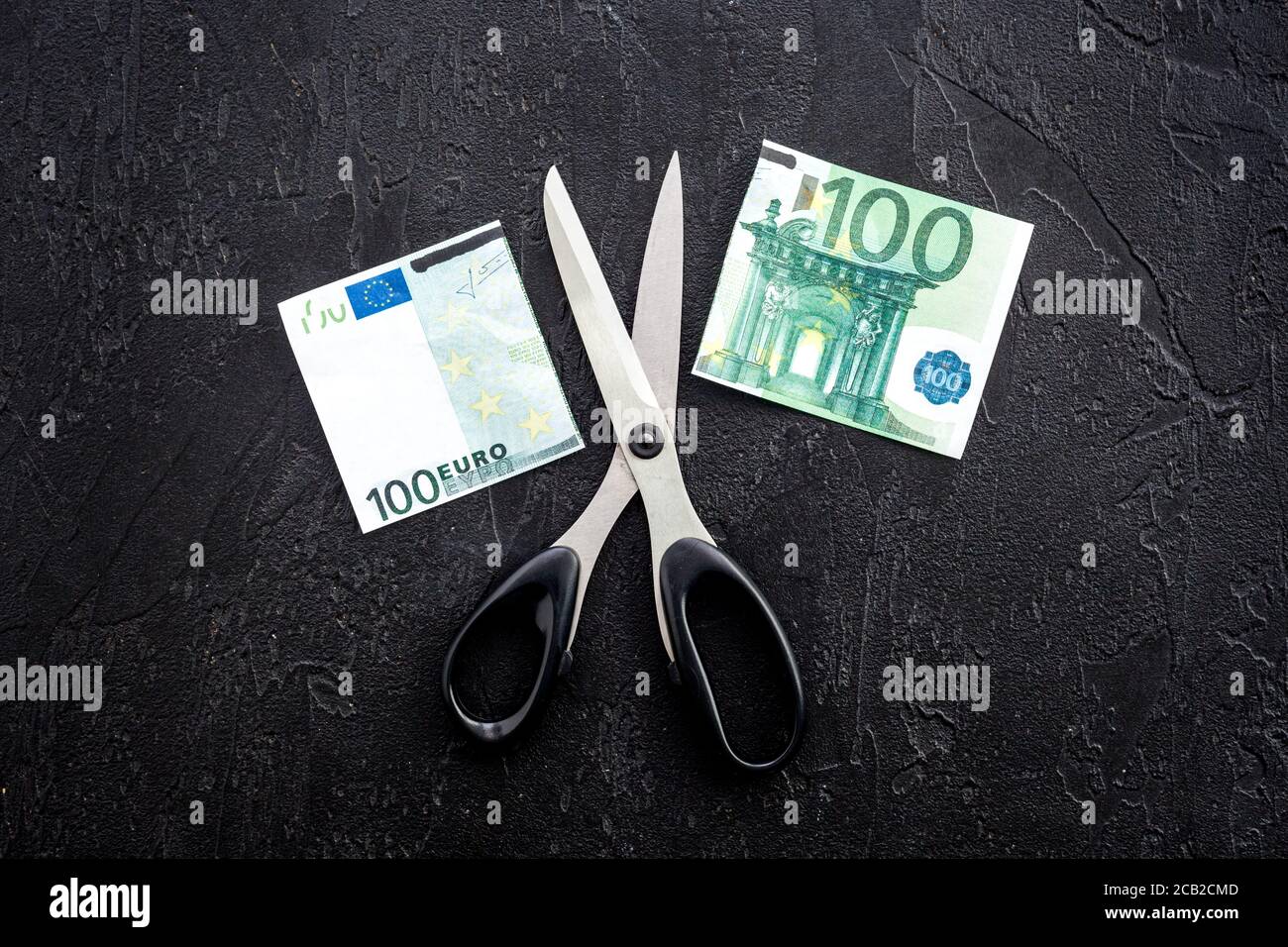 Calo del tasso di cambio dell'euro. Le forbici tagliano banconote da dollari Foto Stock