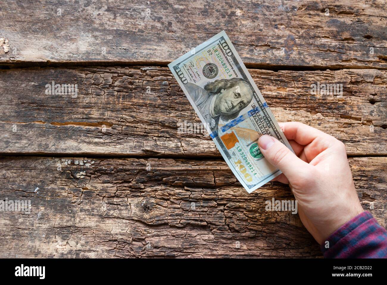 l'uomo paga. tiene in mano un conto di cento dollari Foto Stock