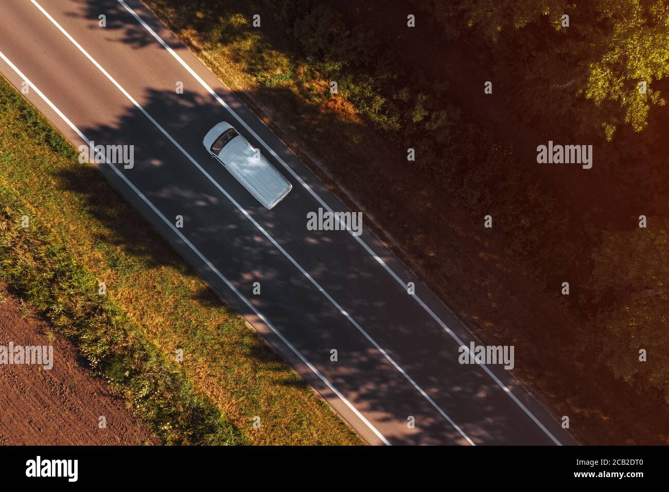 Furgone bianco sulla strada, vista aerea dall'alto dal drone pov, veicolo singolo su autostrada Foto Stock