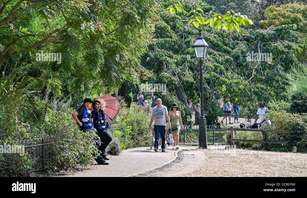 Brighton UK 10 agosto 2020 - il personale di sicurezza trova qualche ombra in Pavilion Gardens Brighton in una calda giornata di sole come le temperature di nuovo raggiungere negli anni 30 in parti del Sud Est : Credit Simon Dack / Alamy Live News Foto Stock