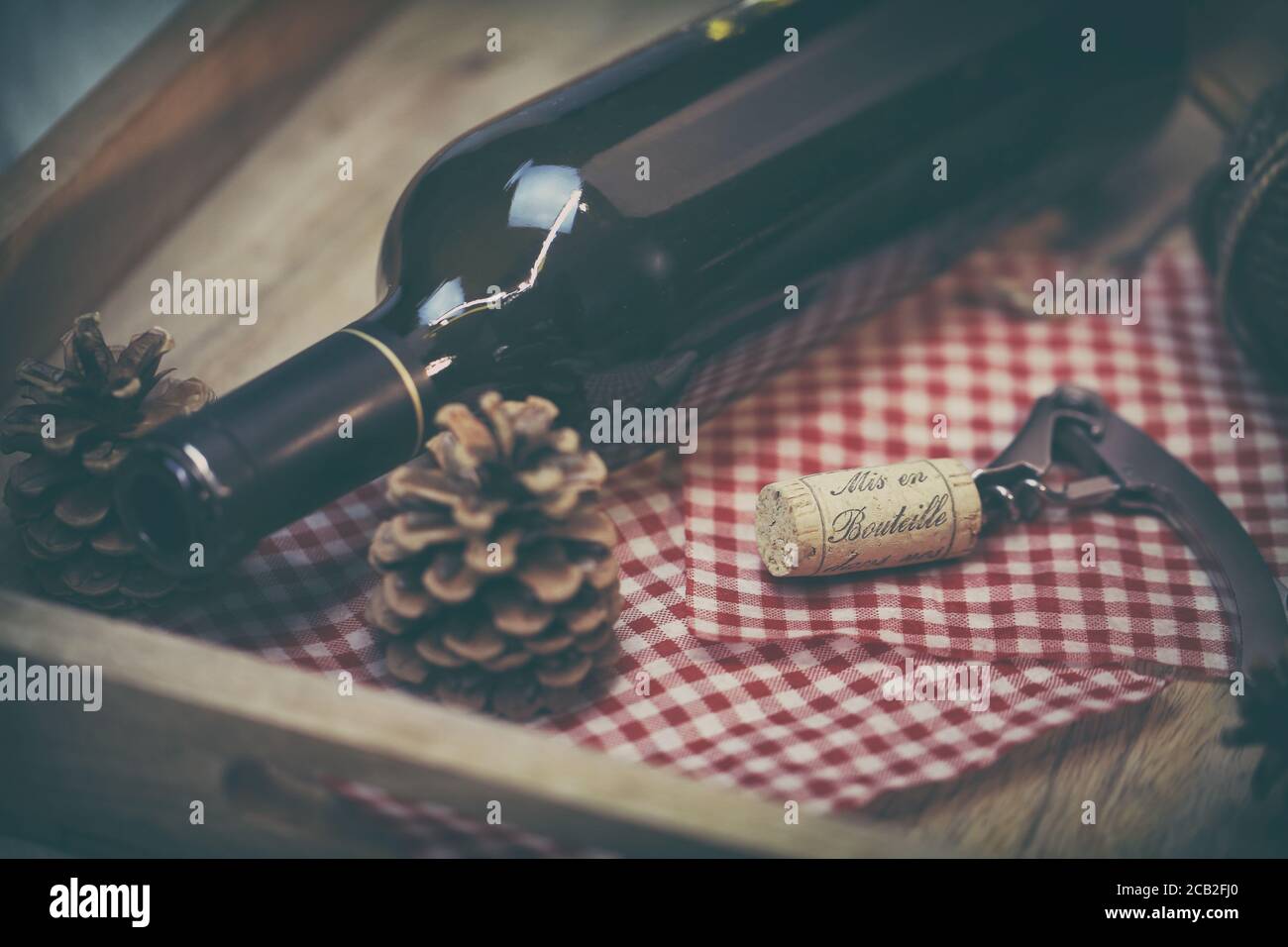 Bouteille de vin rouge et tire bouchon sur une table en bois Foto Stock