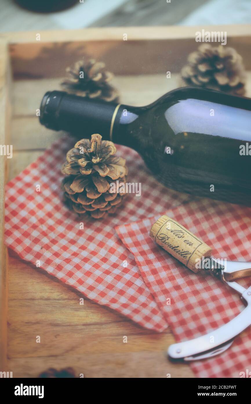 Bouteille de vin rouge et tire bouchon sur une table en bois Foto Stock