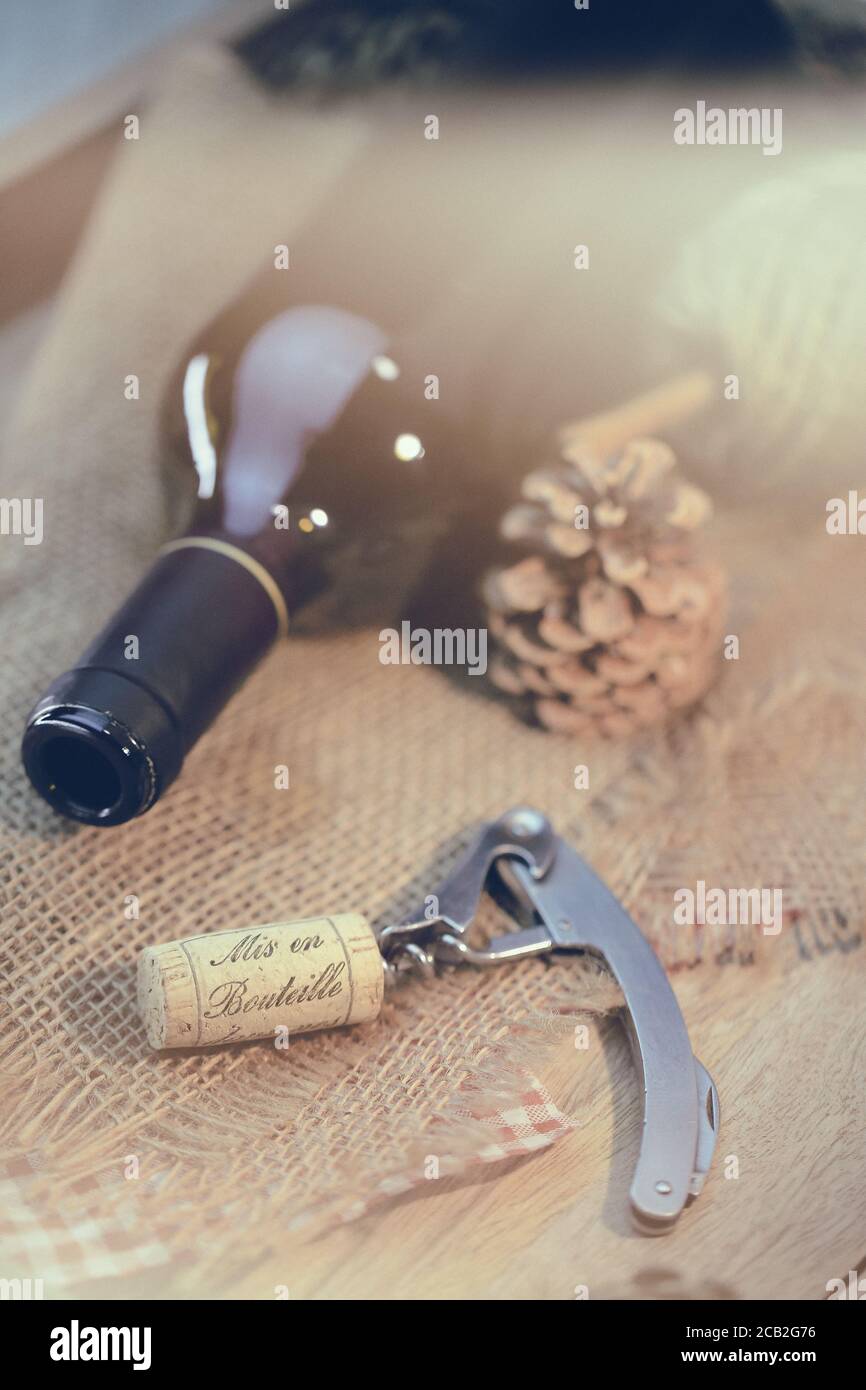 Bouteille de vin rouge et tire bouchon sur une table en bois Foto Stock