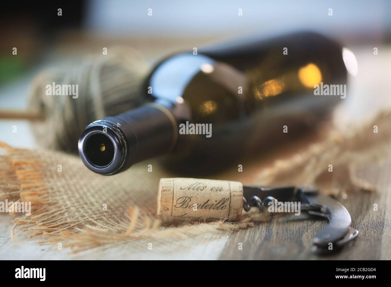 Bouteille de vin rouge et tire bouchon sur une table en bois Foto Stock