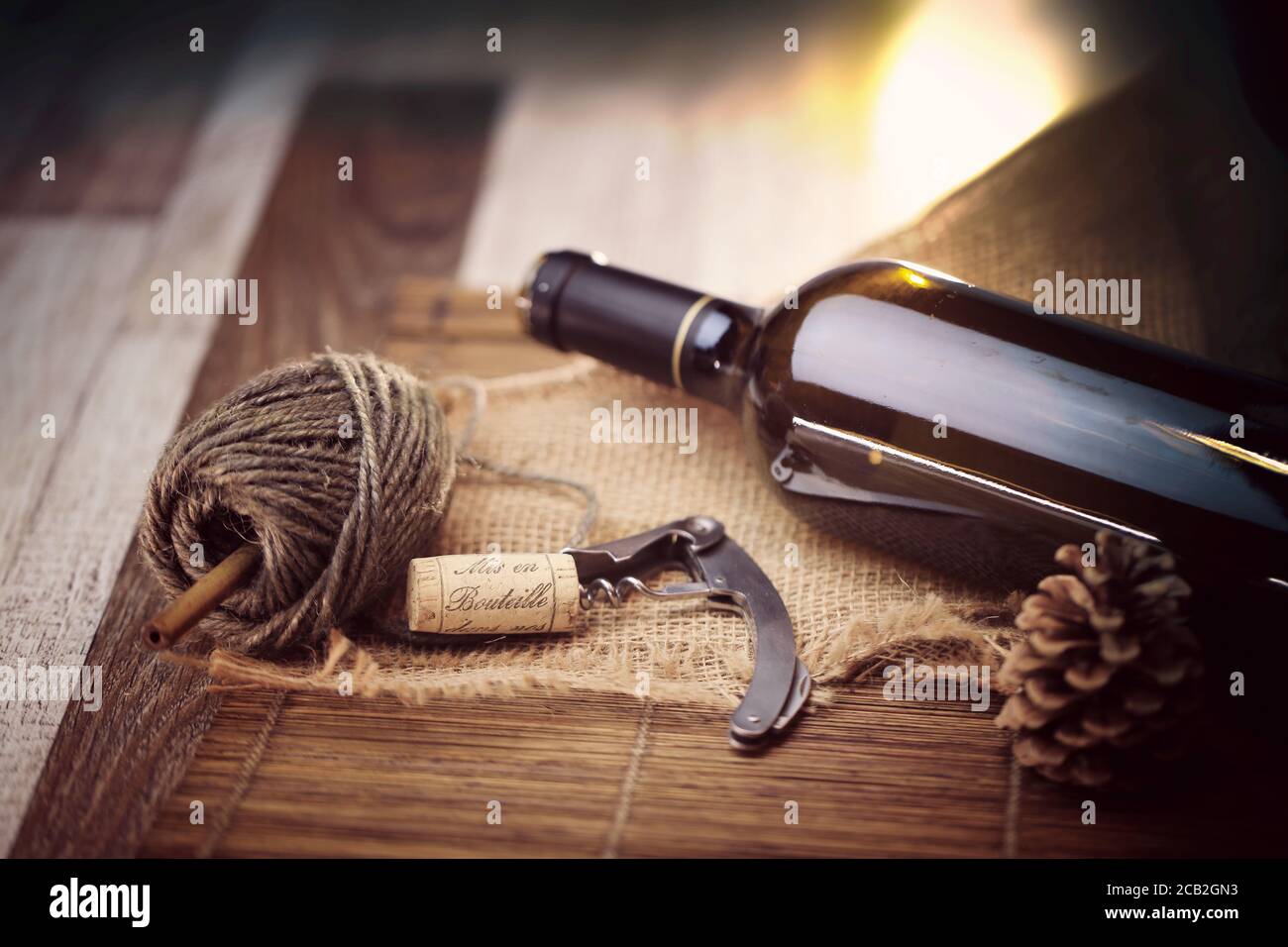 Bouteille de vin rouge et tire bouchon sur une table en bois Foto Stock