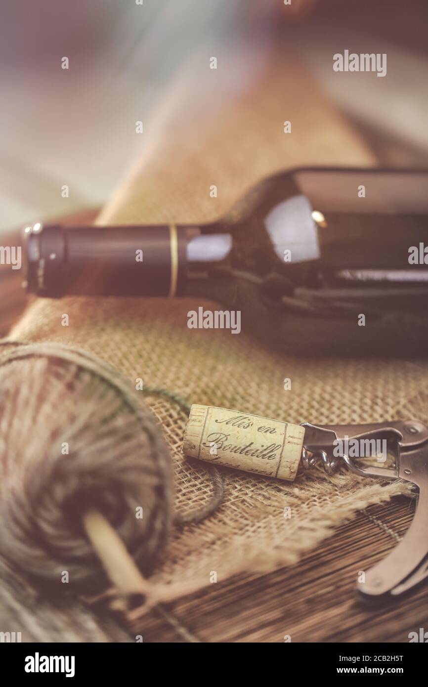 Bouteille de vin rouge et tire bouchon sur une table en bois Foto Stock