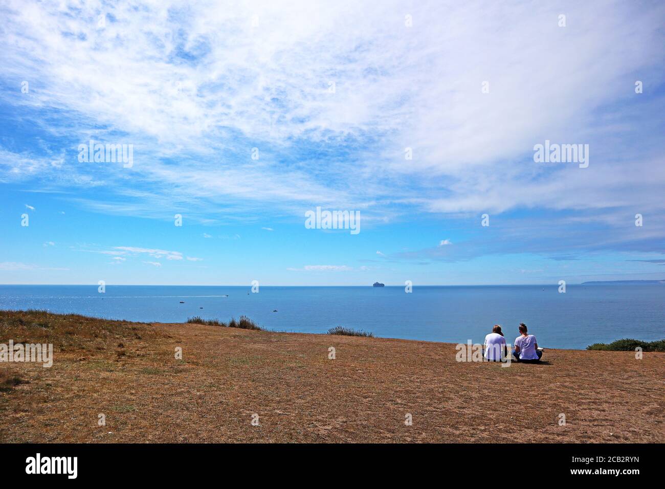 Coppia sulle scogliere di Hengistbury testa guardando oltre Canale in inglese Foto Stock