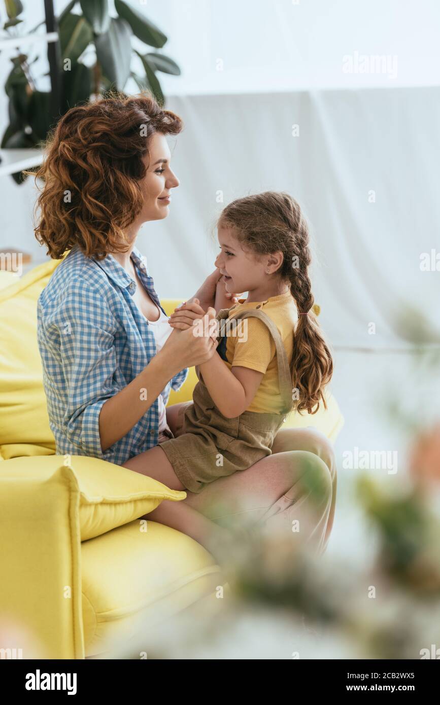 fuoco selettivo di adorabile capretto seduto su giri di sorridente nanny Foto Stock