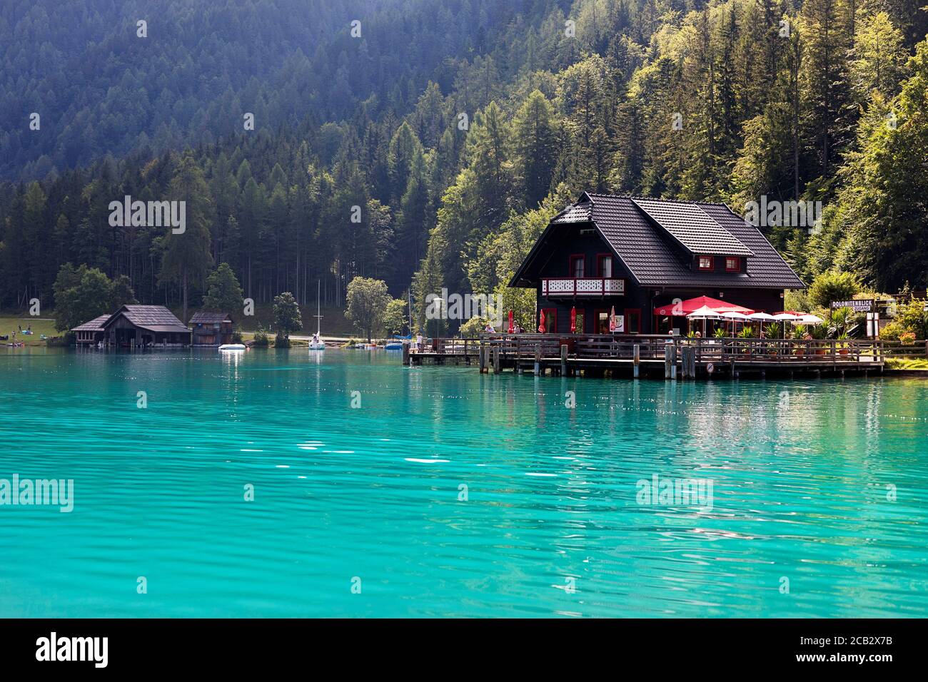 Ristorante e una vecchia casa in legno sulla riva del lago Weissensee nel paesaggio estivo delle Alpi Montagne, Austria Foto Stock