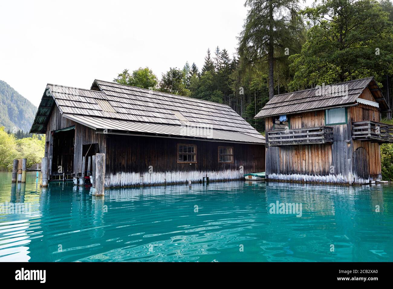 Vecchia barca in legno casa sulla riva del lago Weissensee in estate il paesaggio di montagna delle Alpi, Austria Foto Stock