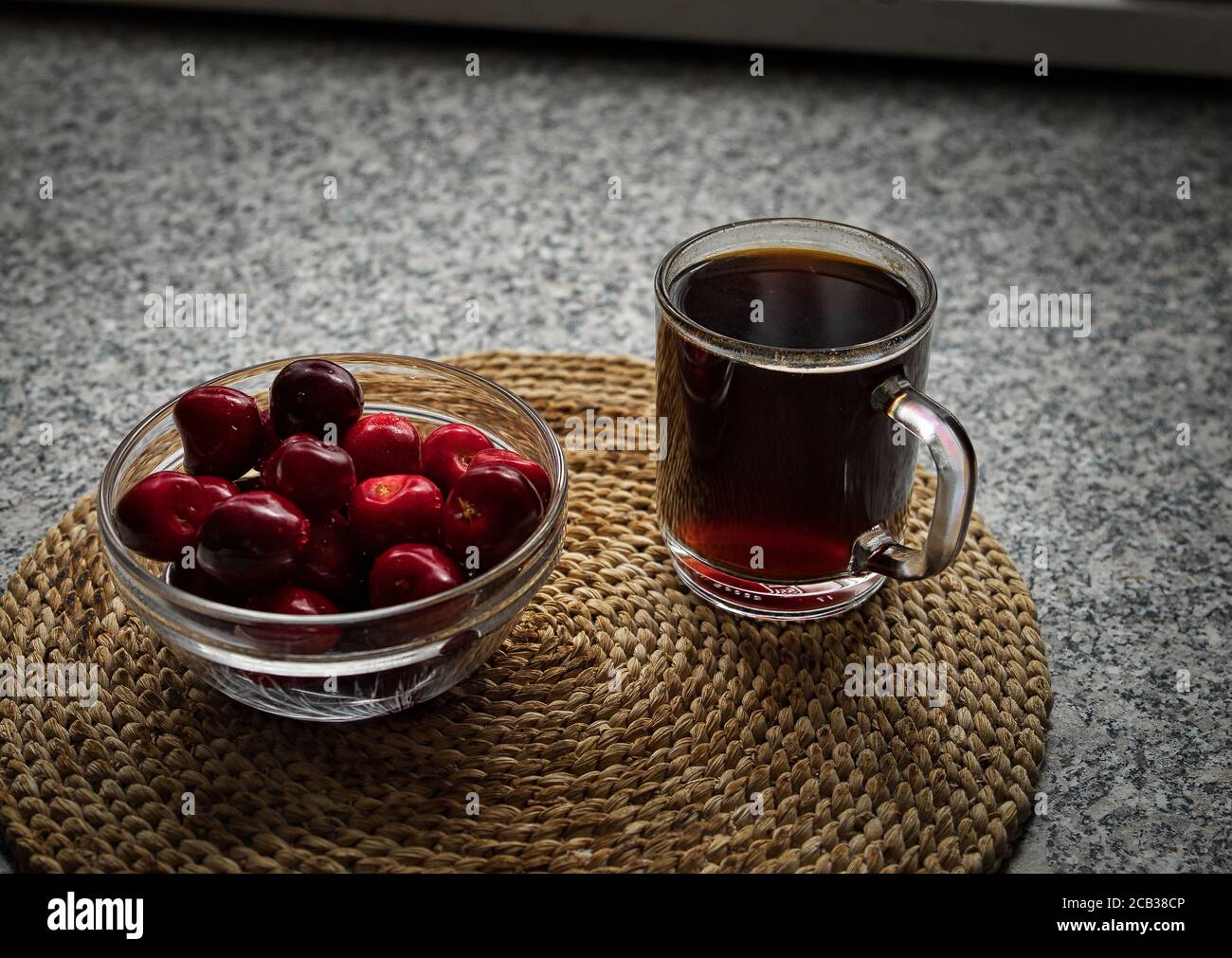 Alcune ciliegie fresche dal proprio giardino con un cubettino di caffè. Foto Stock