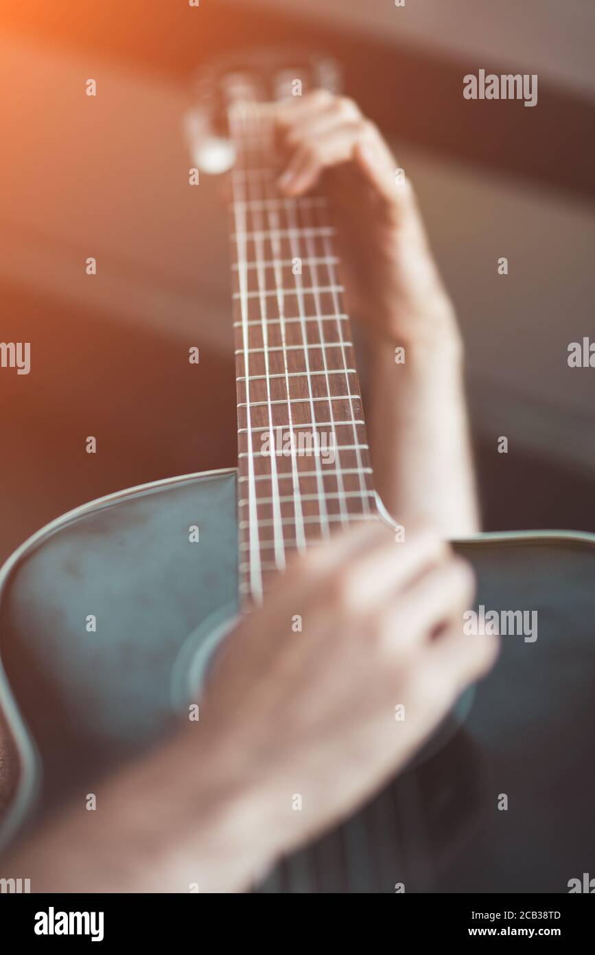 Giocatore con messa a fuoco selettiva per chitarra acustica Foto Stock