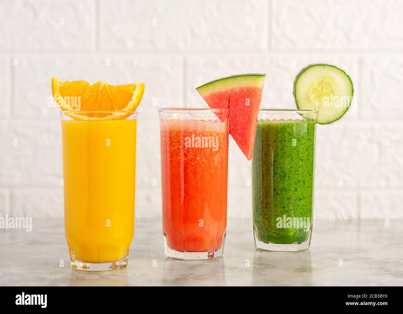 Un bicchiere di succo d'arancia, cocomero e frullato di spinaci. Foto Stock