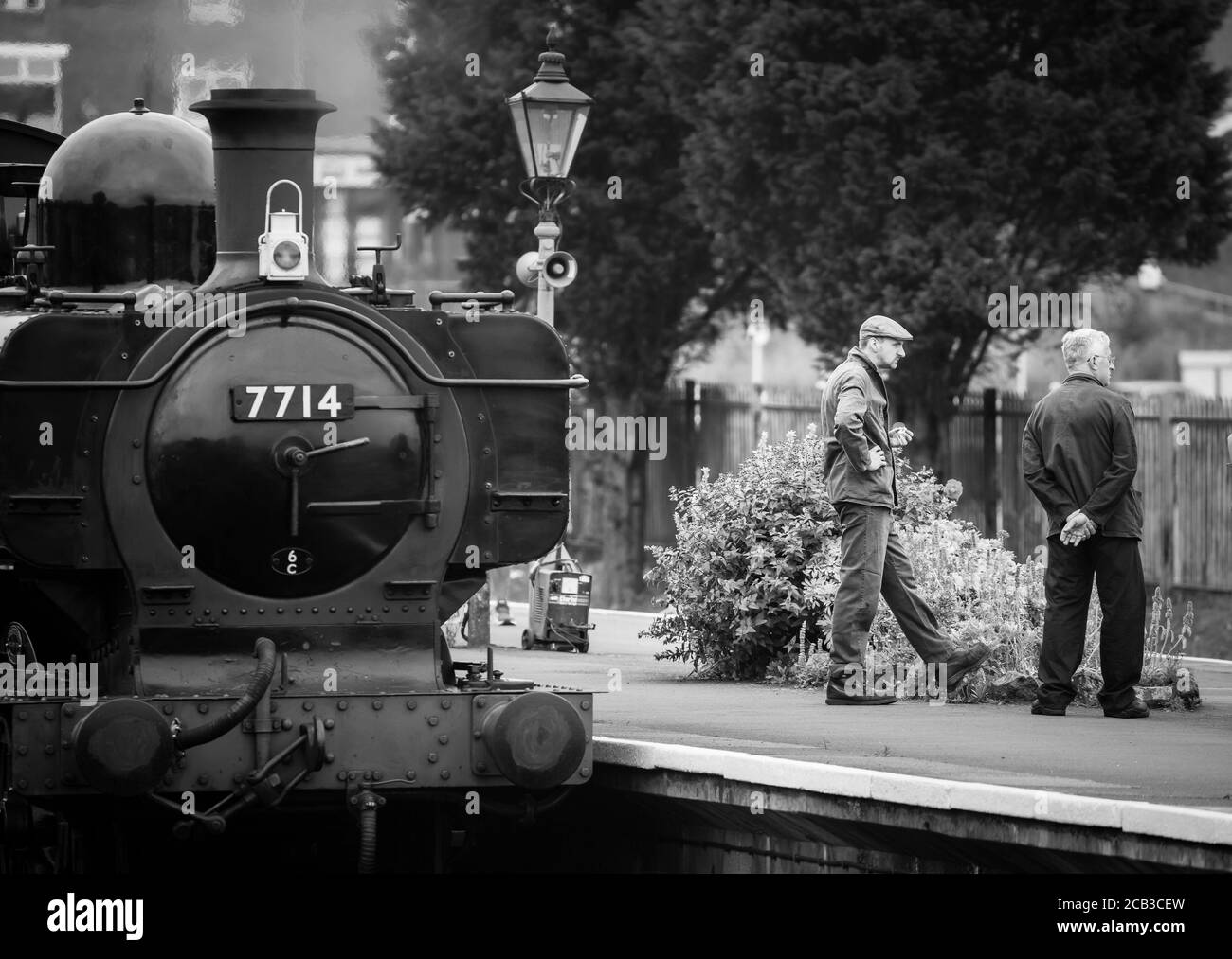 Vista in bianco e nero dell'equipaggio della locomotiva a vapore del Regno Unito che aspetta sulla piattaforma della stazione ferroviaria, Severn Valley Railway, Kidderminster, Worcestershire. Foto Stock