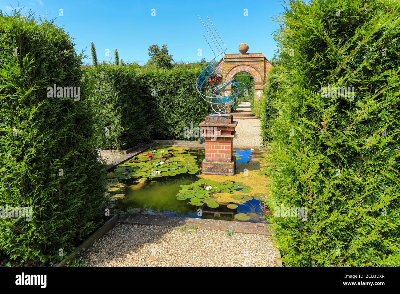 Una scultura in metallo e vetro progettata da Bill Cordaroy nel Rose Garden a East Ruston Old Vicarage Garden, East Ruston, Norfolk, Inghilterra, UK Foto Stock