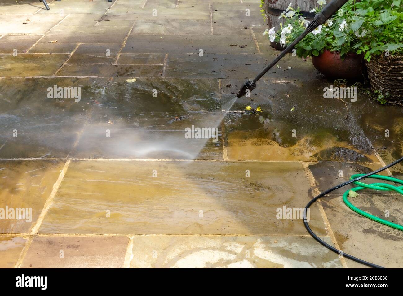 Pulizia patio. Lavaggio a pressione di un patio indiano ardesia. Foto Stock