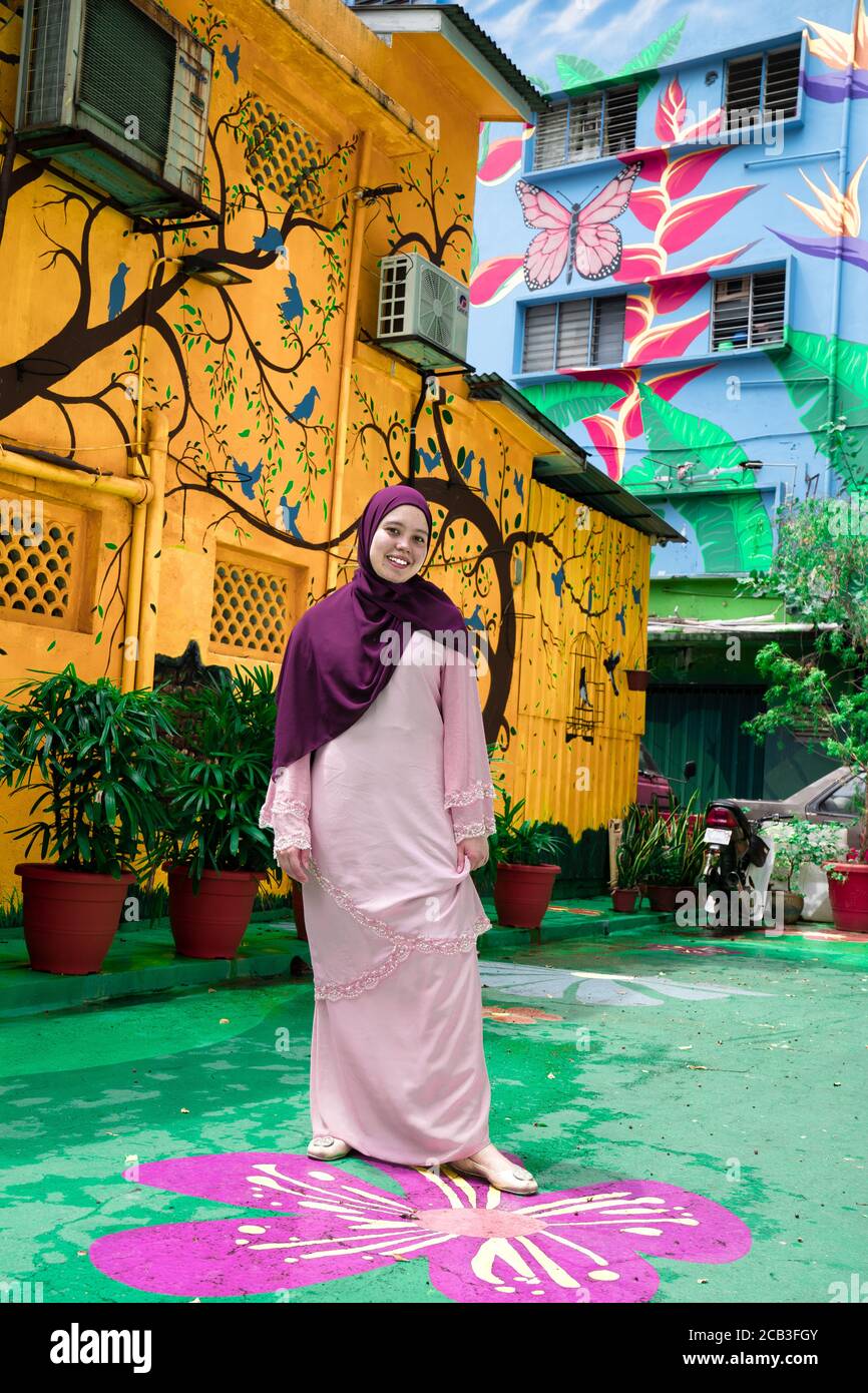 Kuala Lumpur/Malesia/24 Maggio 2020: Giovane bella ragazza musulmana che indossa un copricapo viola e un abito rosa a Jalan Alor, Malesia Foto Stock