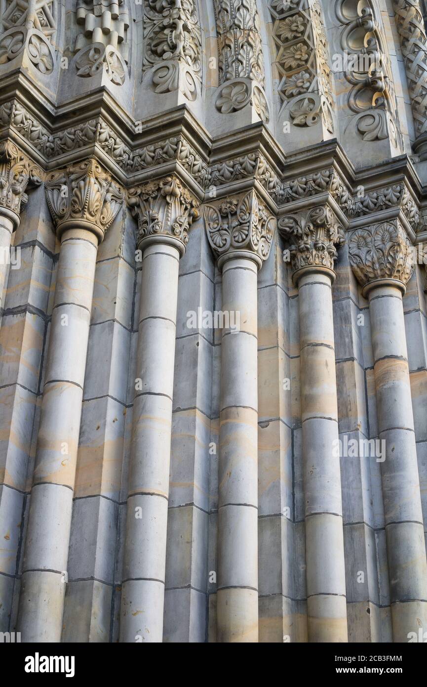 Particolare dell'antico edificio storico in stile architettonico neo-romanico - portale decorato con colonne. Linee verticali Foto Stock