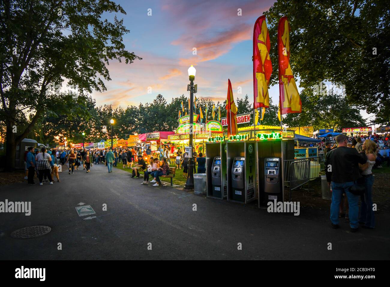 I turisti e la gente del posto apprezzano l'annuale Pig out in the Park in Riverfront Park, Spokane Washington, mentre mangiano presso bancarelle di cibo e venditori mentre la notte cala Foto Stock