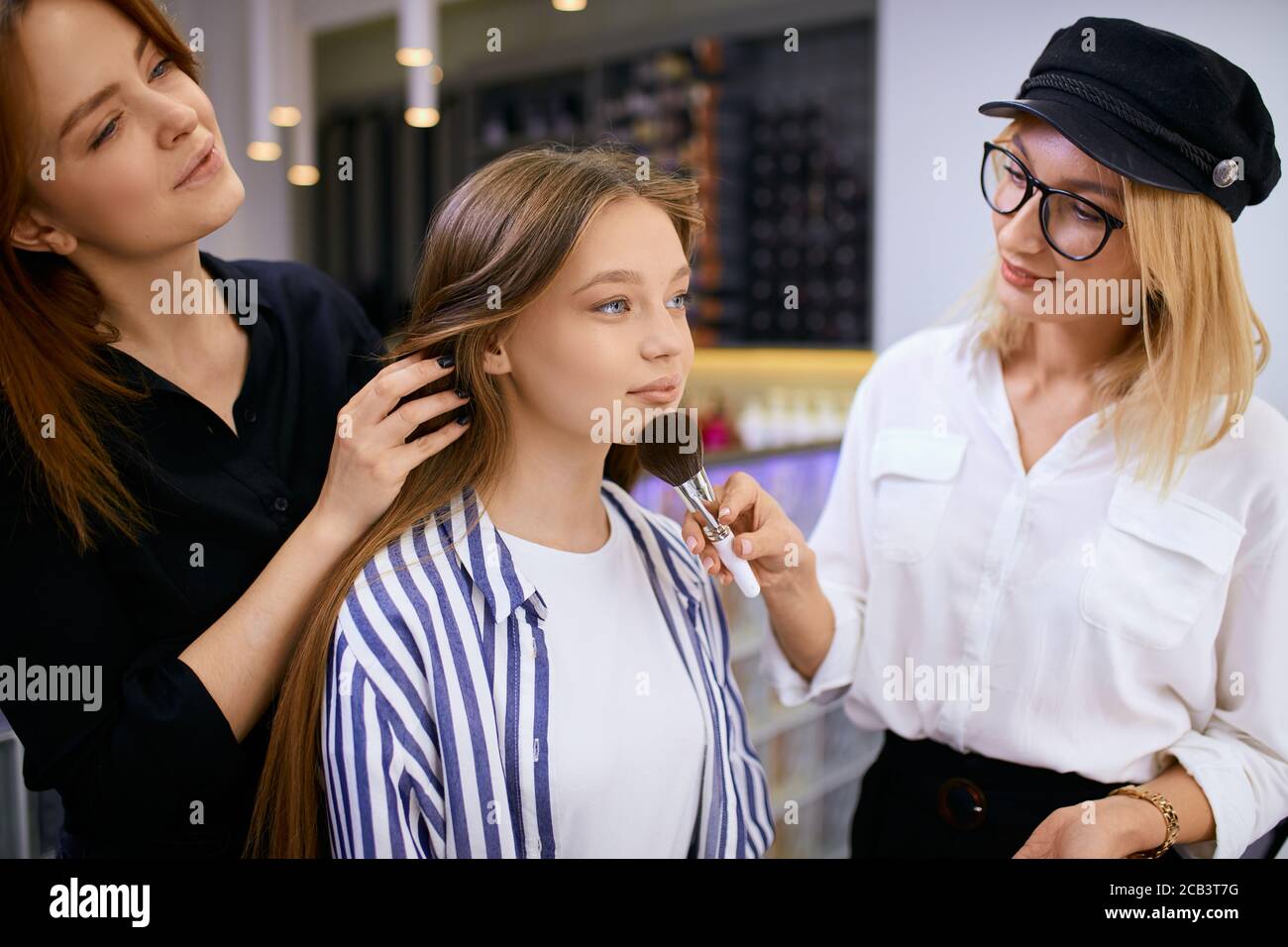 giovane make-up artista e caucasica cliente ragazza in salone di bellezza, facendo il make-up per le vacanze, celebrazione o laurea. Cosmetici decorativi, bellezza pr Foto Stock