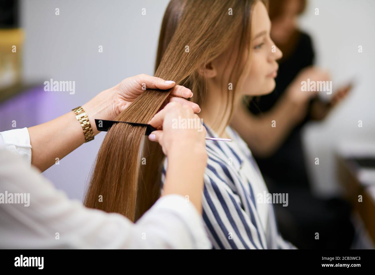 capelli professionali di successo facendo moderni capelli eleganti per giovane bella donna utilizzando attrezzature, forbici Foto Stock