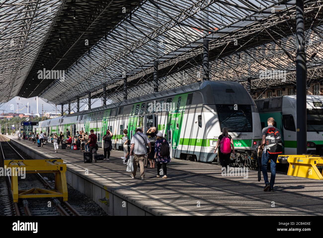 Passeggeri e treni alla stazione ferroviaria centrale di Helsinki, Finlandia Foto Stock