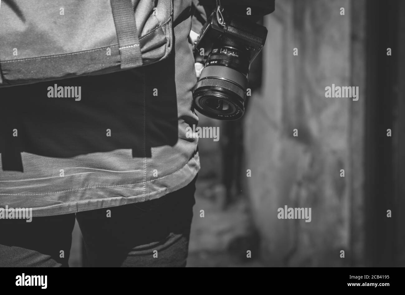 Primo piano in scala di grigi di un fotografo con una fotocamera, vista dal retro Foto Stock