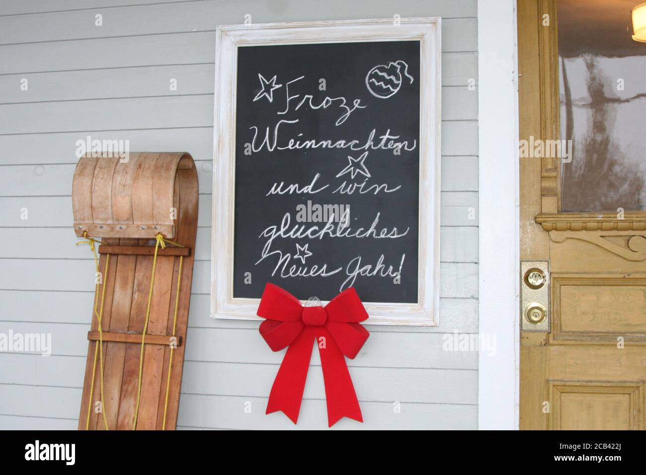 Toboggan e lavagna a muro traduzione: Buon Natale e un felice anno nuovo Foto Stock