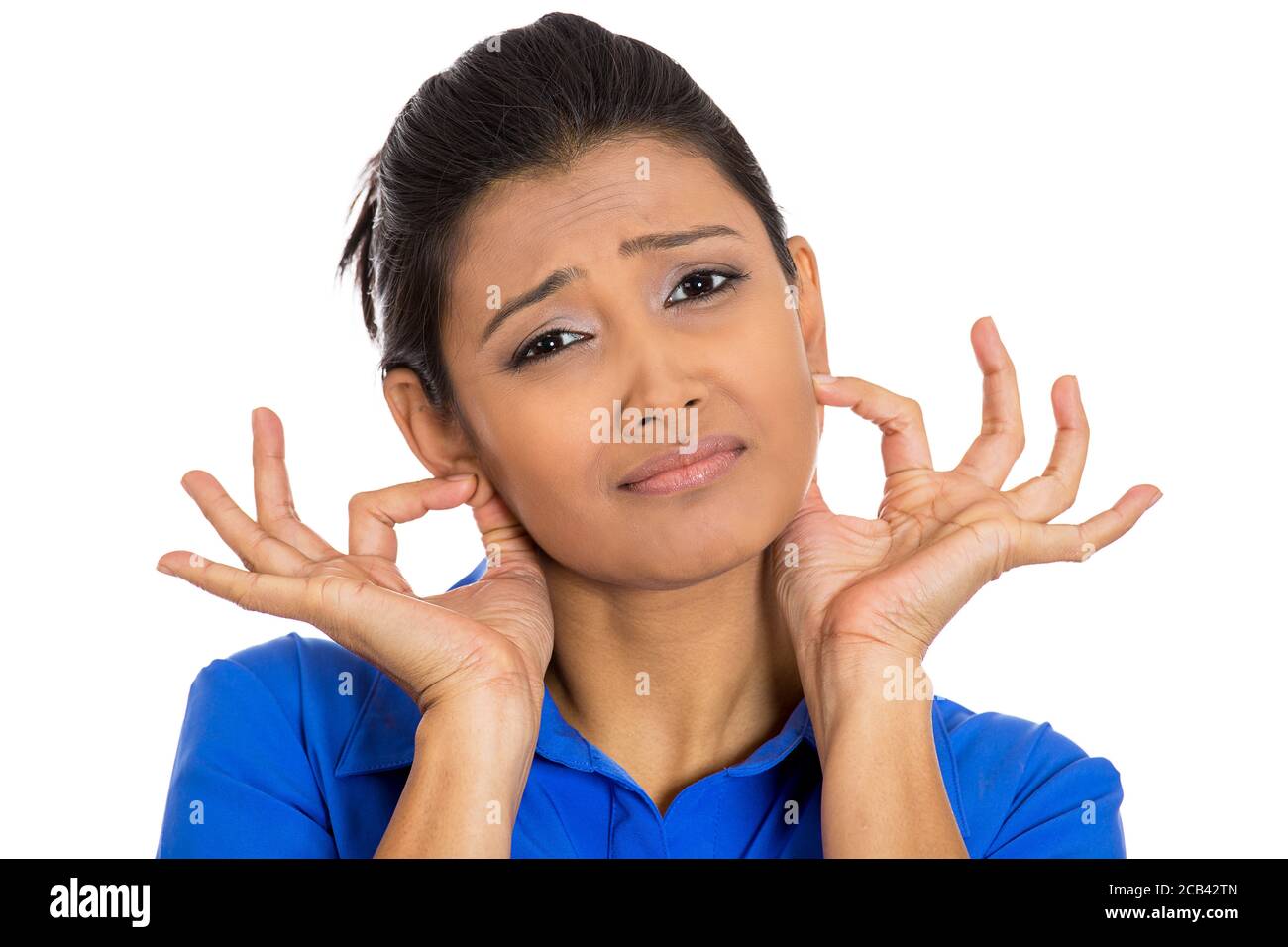 Ritratto closeup di una giovane donna che tira le orecchie di presa spiacente per quello che ha fatto, isolato su sfondo bianco. Emozioni umane negative, espressioni facciali Foto Stock