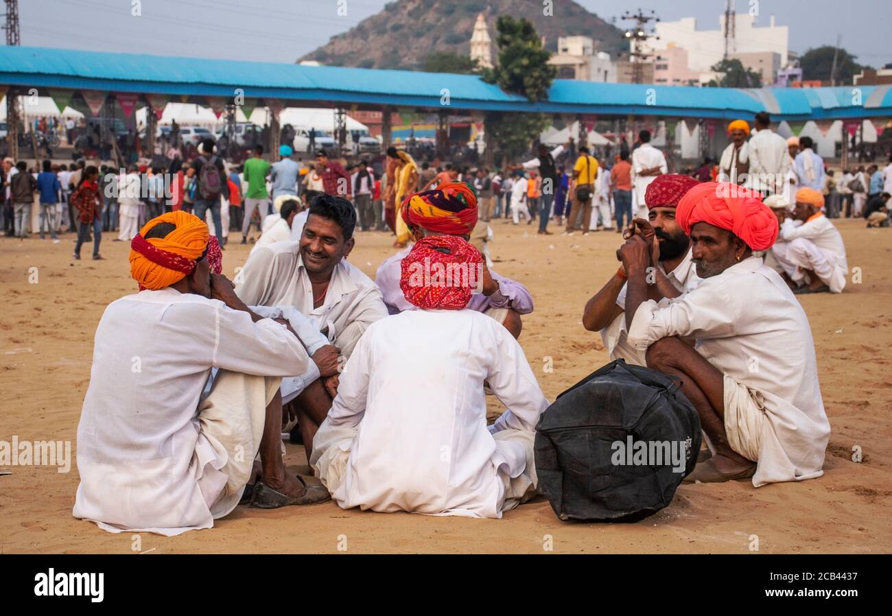 11 Dicembre 2019 Pushkar Rajesthan, India uomo seduto a terra durante la fiera di Pushkar in pushkar terreno fiera. Foto Stock