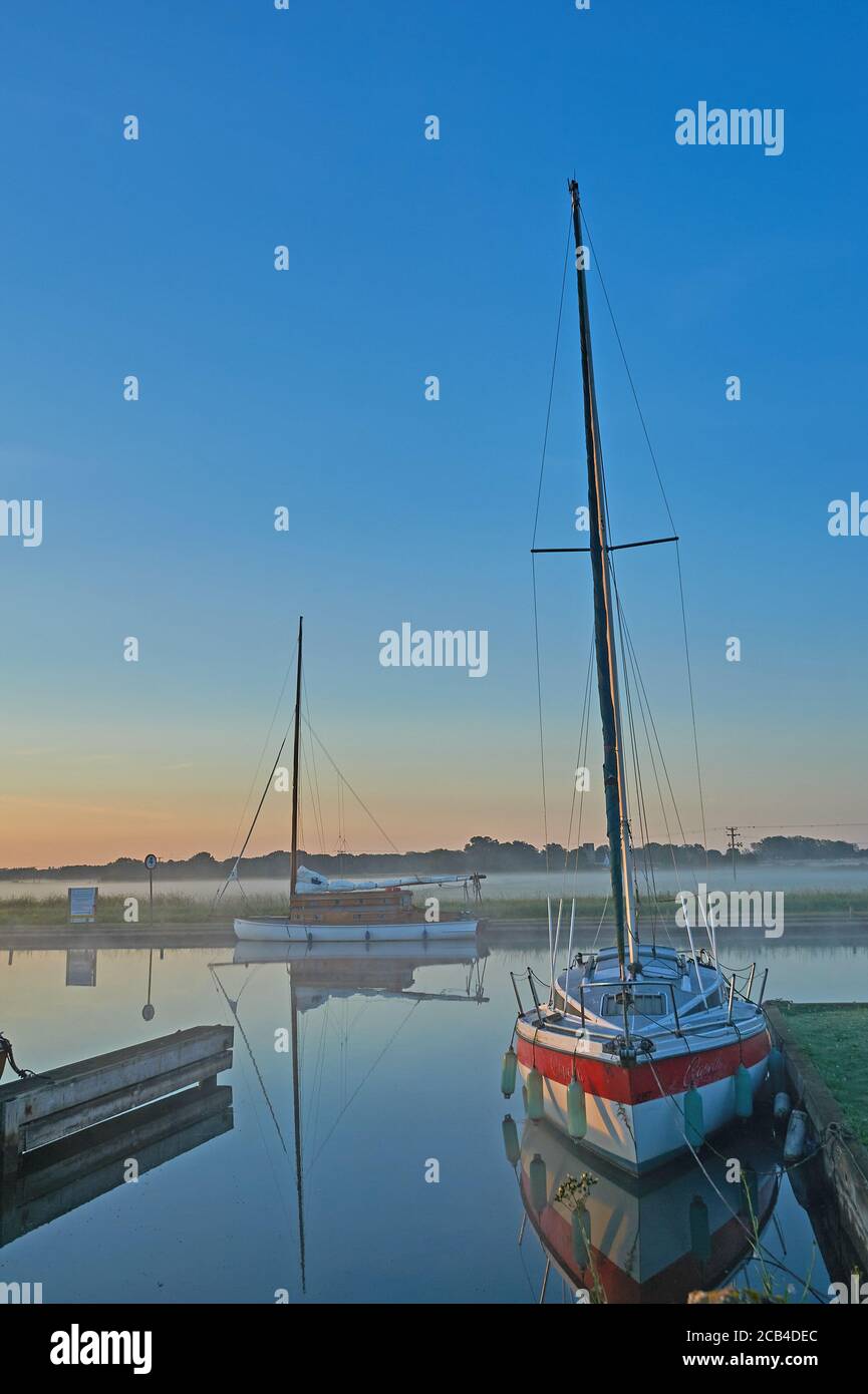 Potter Heigham, Norfolk .Broads, barche a vela ormeggiate sul fiume Thurne in una nebbiosa mattina d'estate Foto Stock