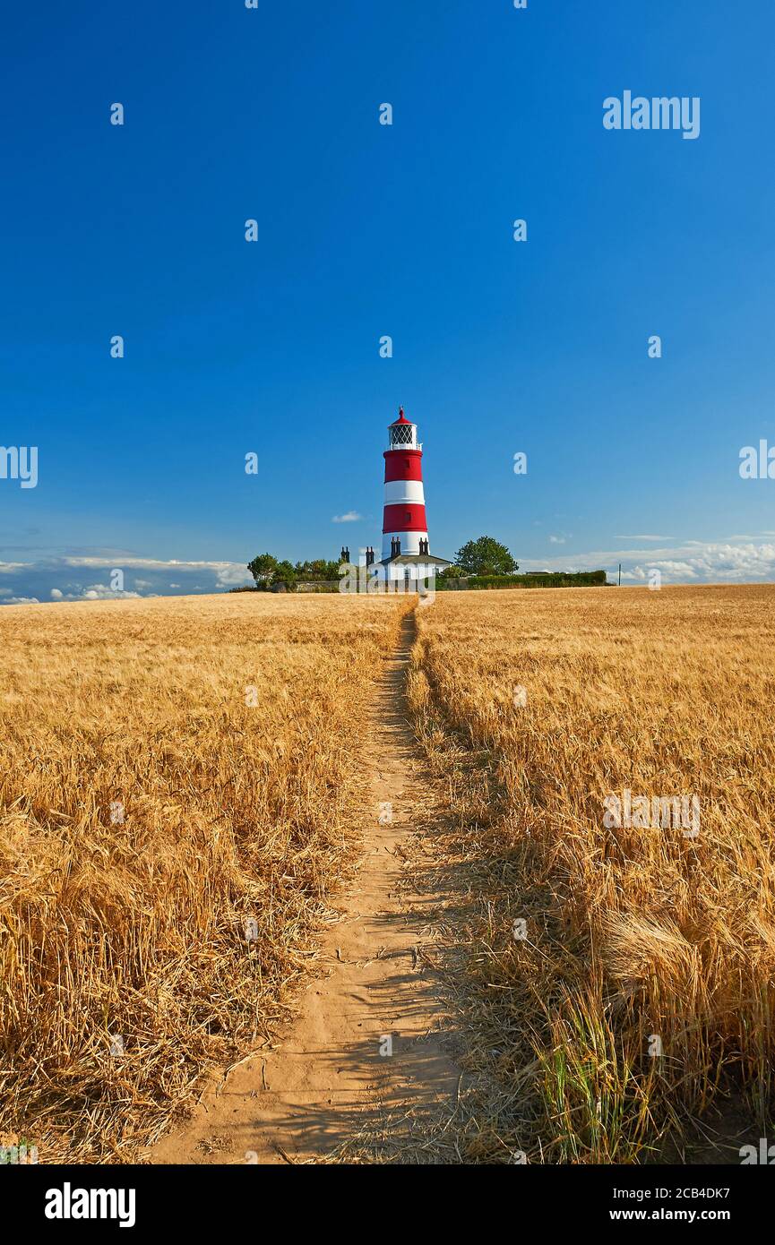 Happisburgh, Norfolk, il faro a strisce rosse e bianche contro un cielo blu Foto Stock