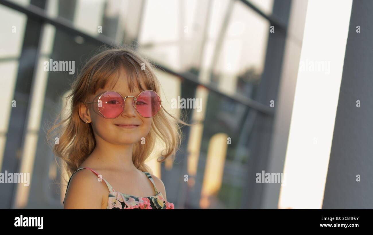 Bambina al tramonto con occhiali da sole eleganti in aeroporto. Bambino  turistico in tute con fiori. Aspetto di stile Hawaiiano. Vacanze, turismo,  viaggio Foto stock - Alamy