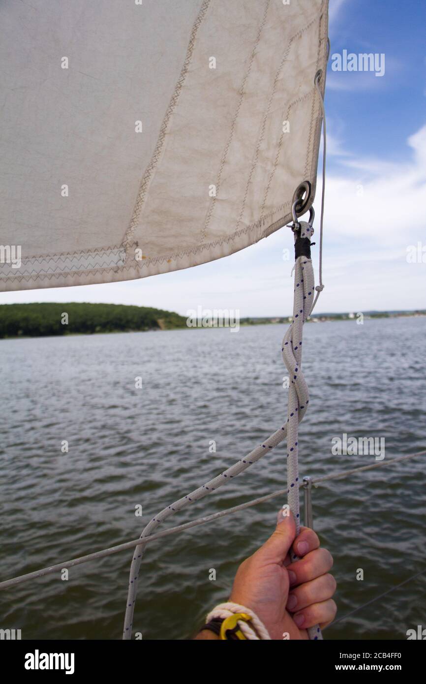 Mano di capitano barca a vela che lavora su barca con attrezzatura. Shine Yacht Tackle durante il viaggio, concetto di vela. Foto Stock