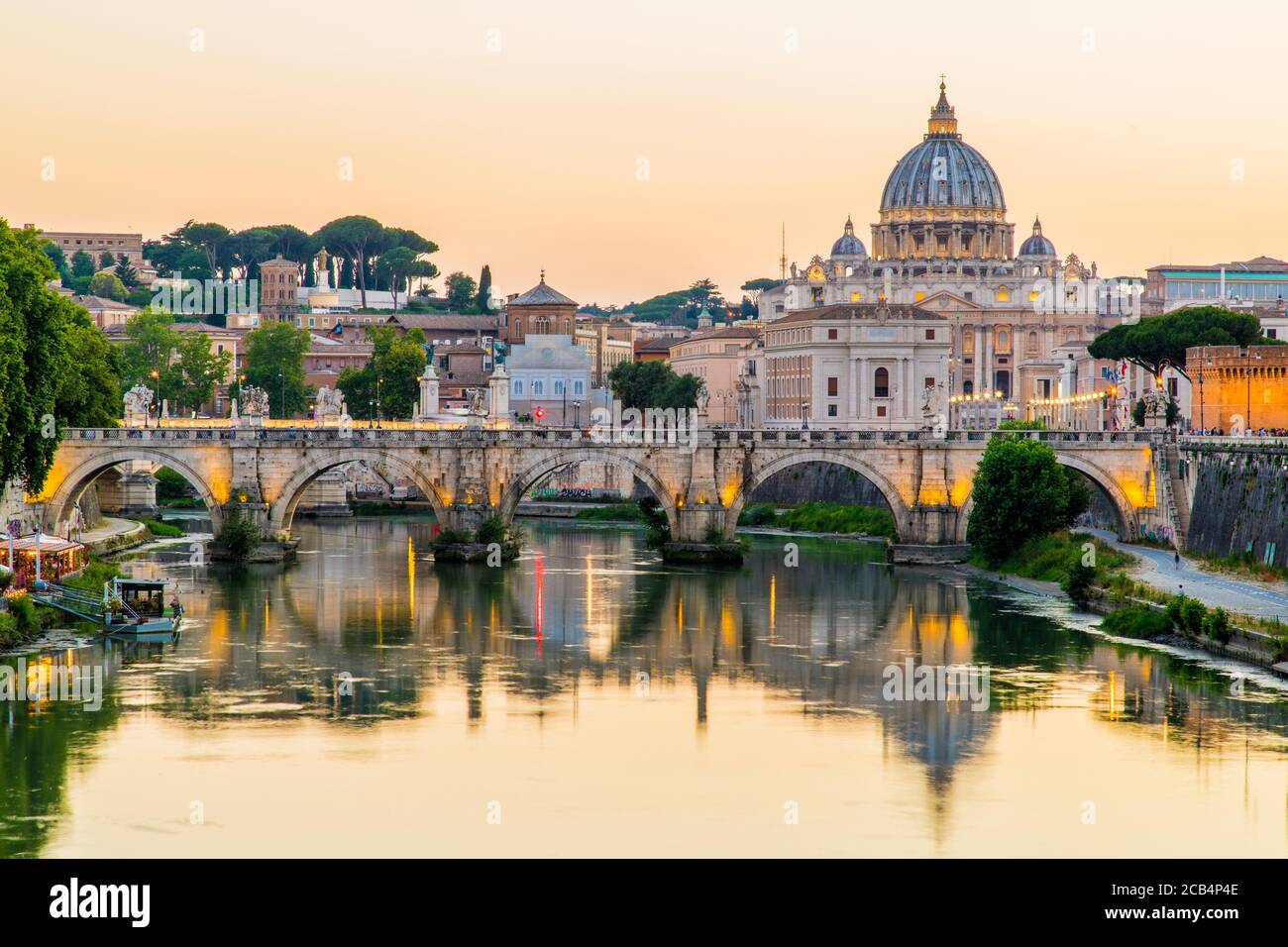 Una vista della Basilica di San Pietro e della Città del Vaticano al tramonto lungo il Tevere a Roma, Italia Foto Stock