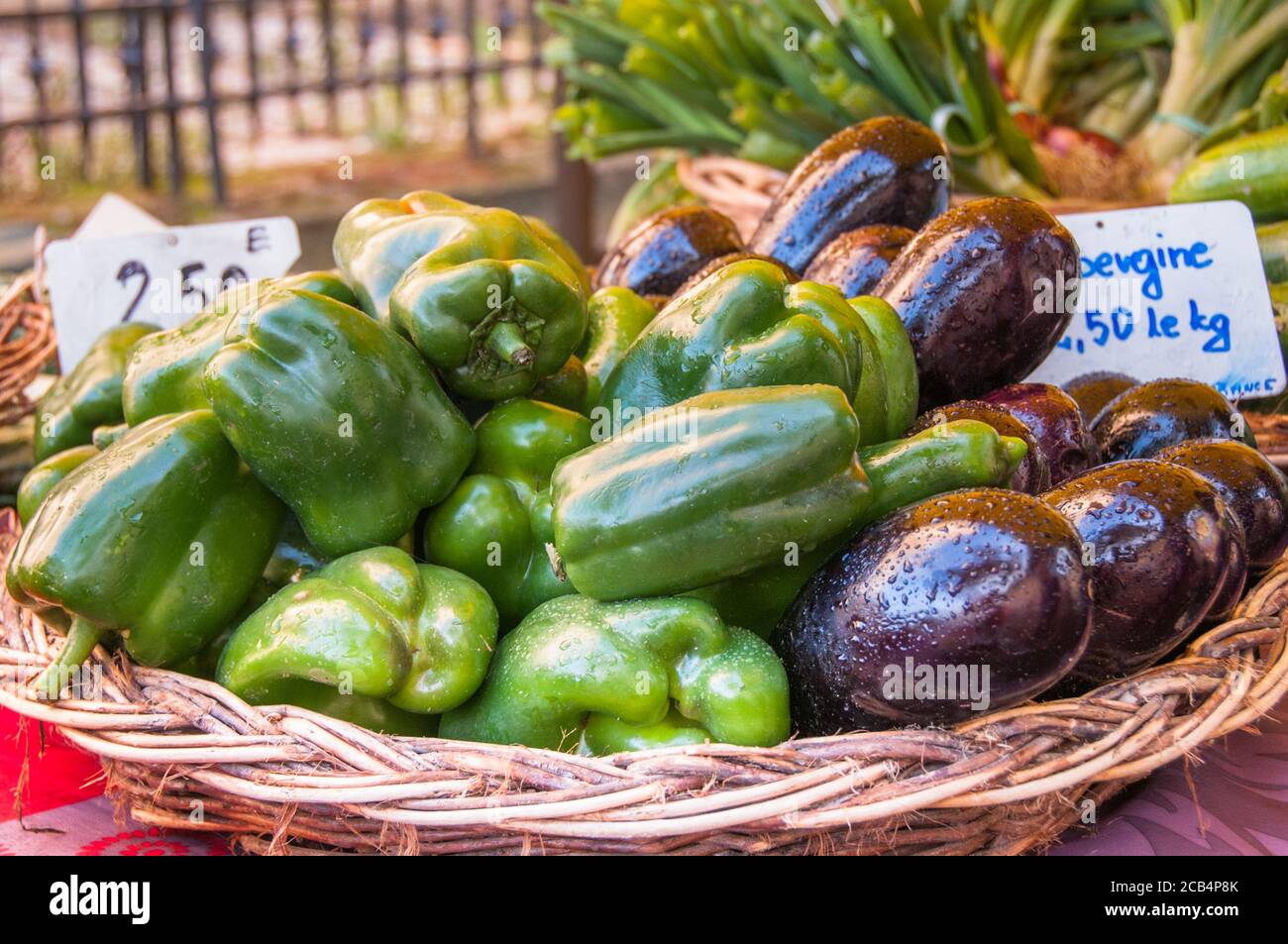 Verdure fresche di melanzane e peperoni verdi in un cestino a. Un mercato agricolo francese Foto Stock