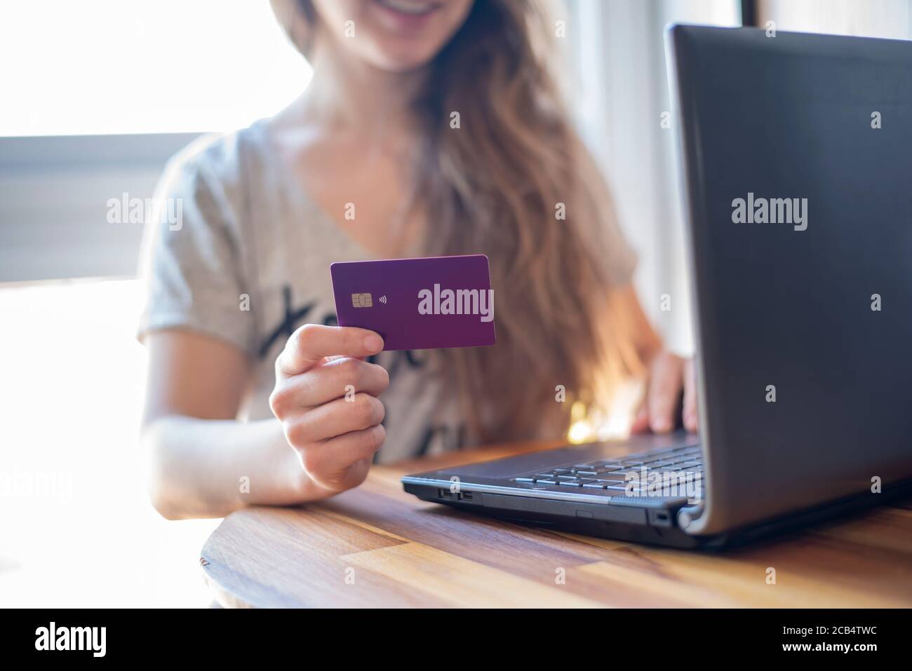 Donna felice che acquista online su carta di credito Foto Stock