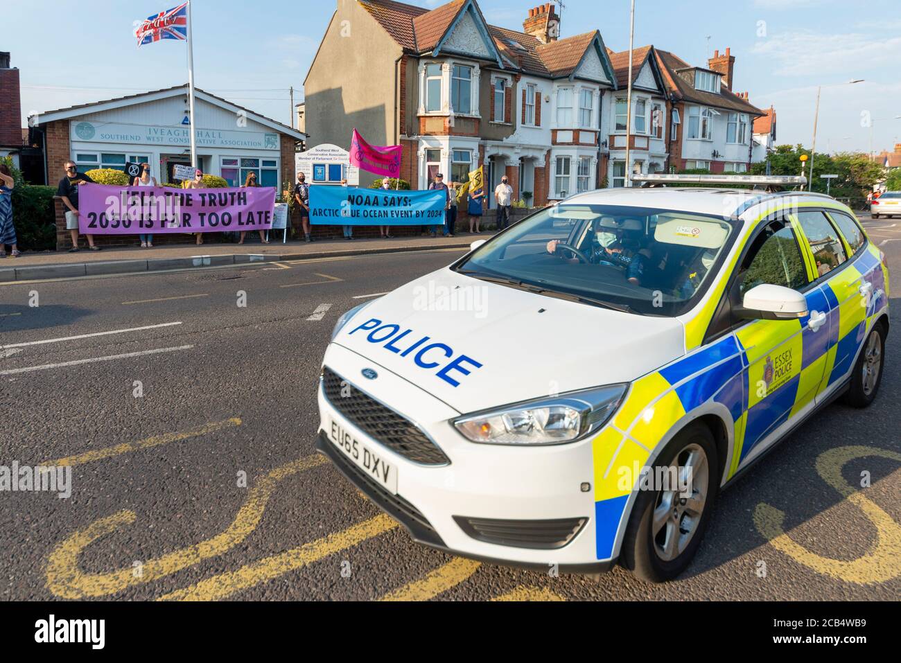 Estinzione la ribellione, filiale di Southend, ha effettuato una protesta contro il cambiamento climatico fuori dall'ufficio conservatore del deputato di Southend West. Auto della polizia in arrivo. Mascherato Foto Stock