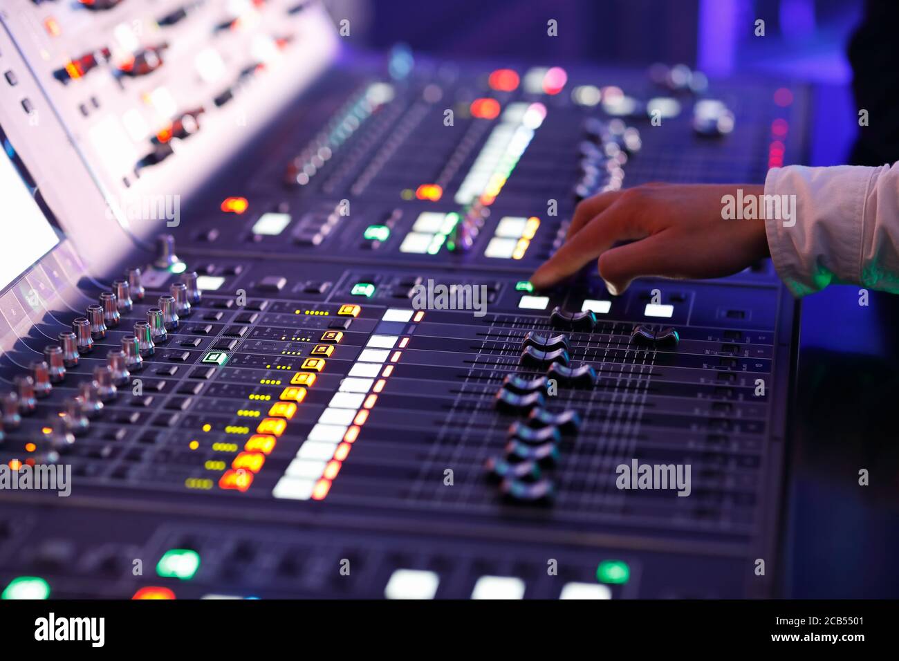 Tecnico del suono che lavora con i comandi di una console di mixaggio del suono. Messa a fuoco selettiva. Foto Stock