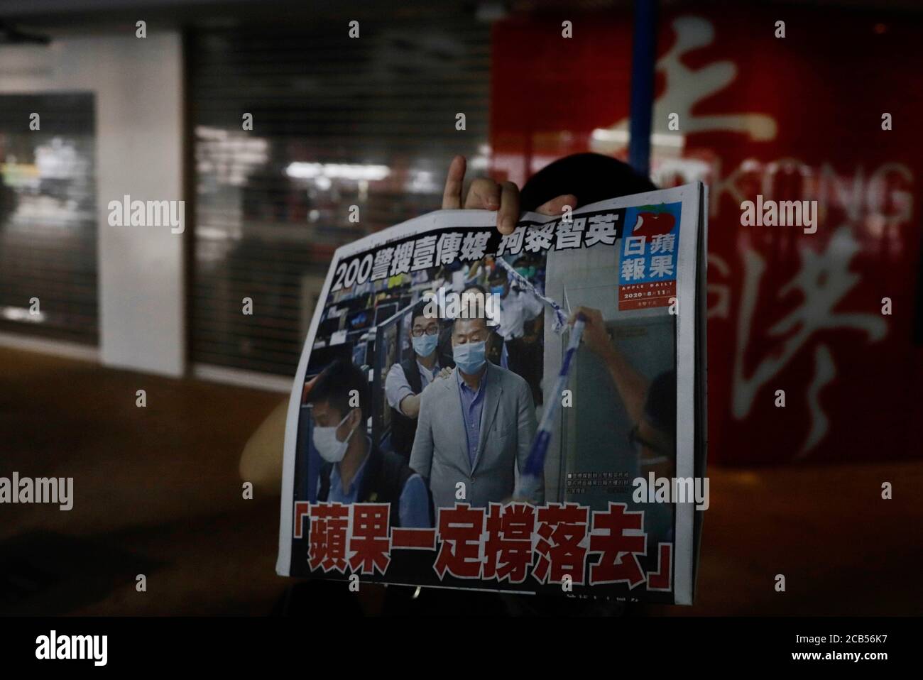 Hong Kong, CINA. 11 Agosto 2020. Una donna reagisce visualizzando l'immagine dell'intestazione raffigurante l'arresto del fondatore DEL QUOTIDIANO DI APPLE, Jimmy Lai sulla copia di Apple Daily mentre lascia lo stand di notizie al molo di Star Ferry, sul titolo è scritto: 200 poliziotti hanno cercato I MEDIA SUCCESSIVI, arrestando Jimmy Lai. APPLE TERRÀ IL.ago-11, 2020 Hong Kong.ZUMA/Liau Chung-ren Credit: Liau Chung-ren/ZUMA Wire/Alamy Live News Foto Stock