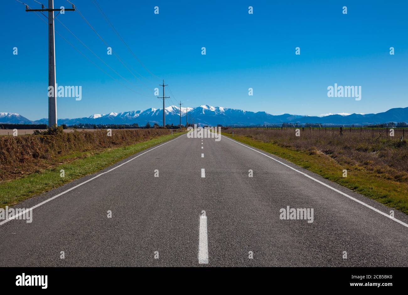 Scene della campagna della Nuova Zelanda: Le strade dritte e pianeggianti di Canterbury. Foto Stock