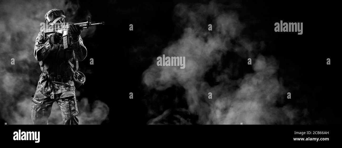 Soldato di forze speciali che puntano sul bersaglio. Fanteria lotta contro il terrorismo. Commando su sfondo fumoso con fucile. Foto Stock
