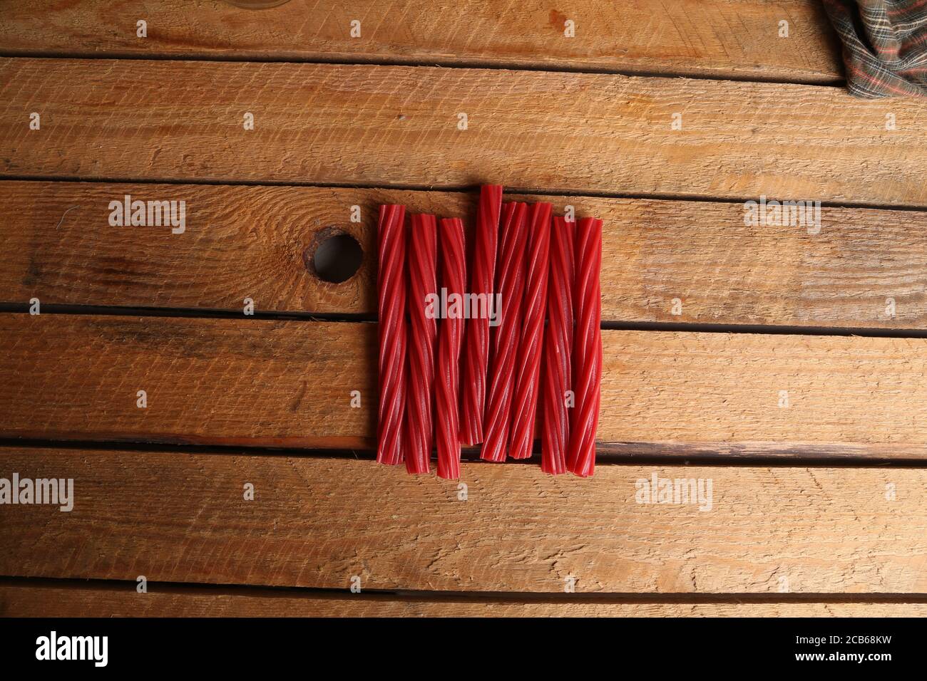 Vista dall'alto di lunghe caramelle rosse ritorte che si abbaparano su un  tavolo di legno Foto stock - Alamy