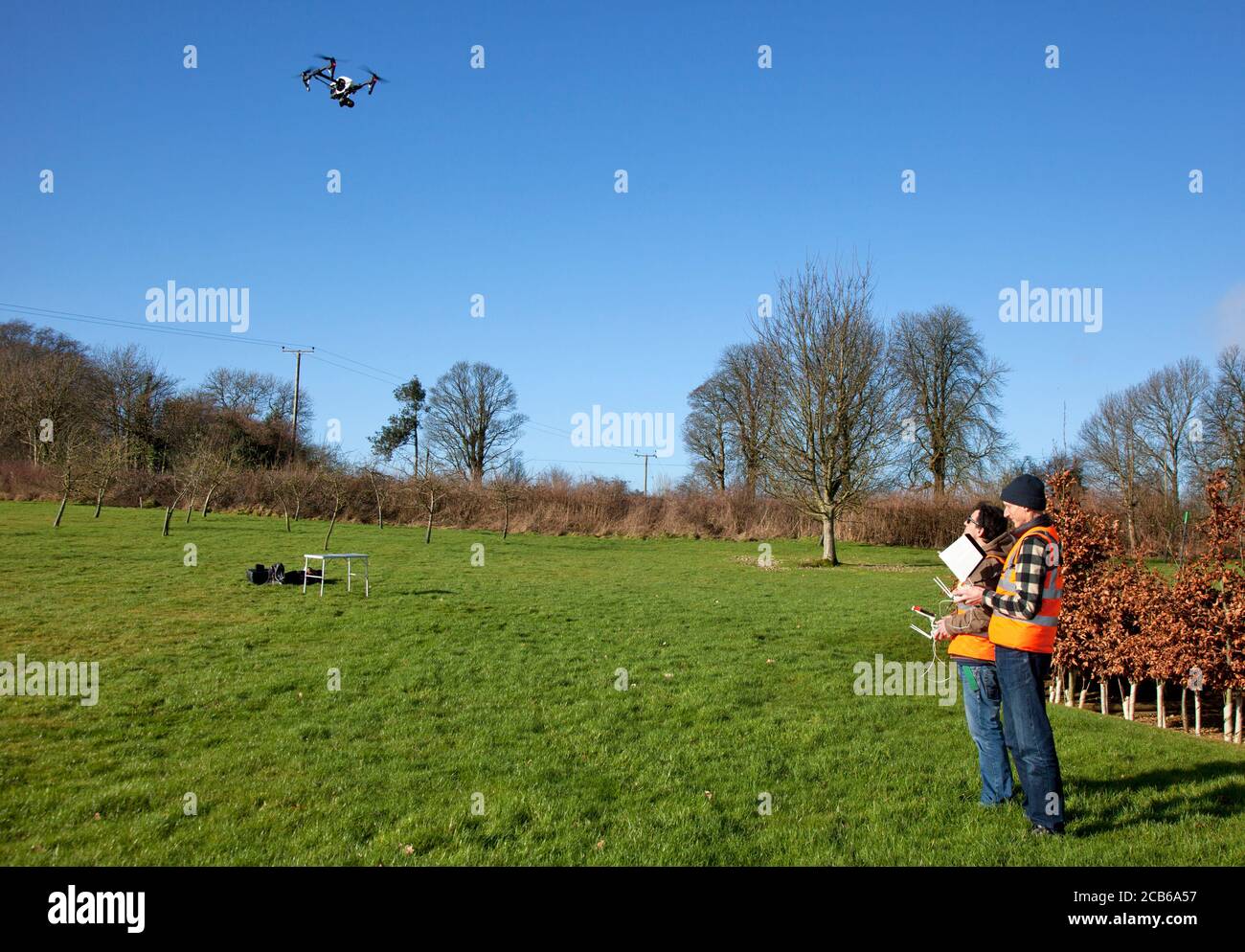 Due fotografi professionisti che volano un drone con una fotocamera accesa Terreno privato nei Cotswolds Foto Stock